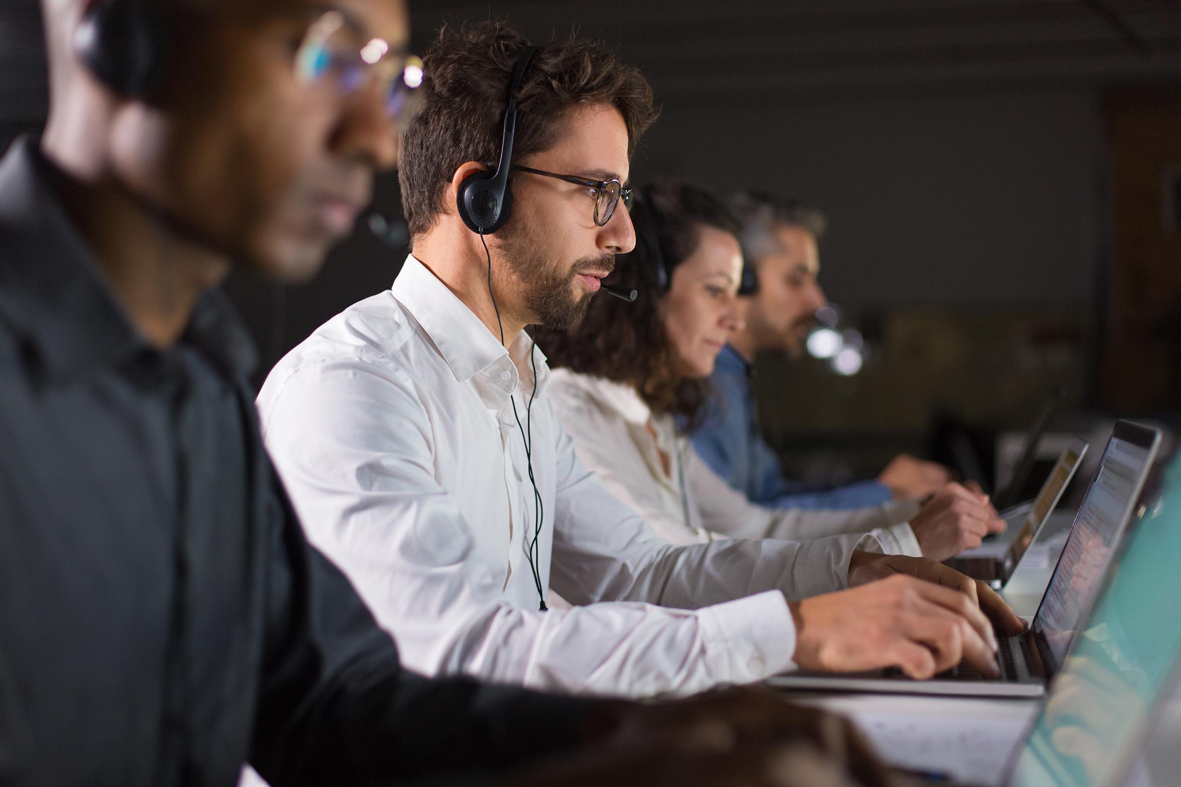 Support professional with headset working at a laptop